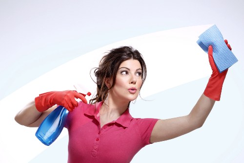 Local cleaner working on shopfront windows in Sutton